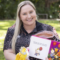 JCU Bachelor of Education (Early Childhood Education) student Tabitha McCann holding a children's picture book. 