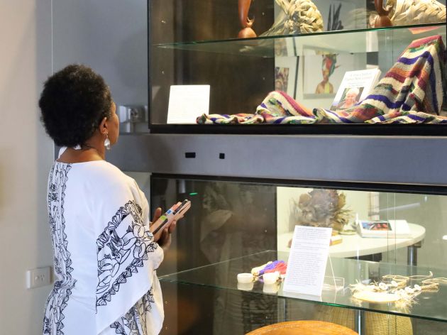 A woman looks at Maggie Wilson's memoir in the exhibtiion case. 