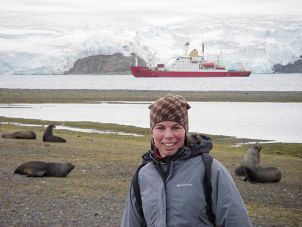 Jan Strugnell in the Antarctic with the ship James Clark Ross in the background